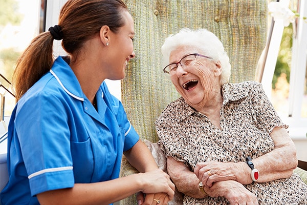 Medical professional laughing with senior woman